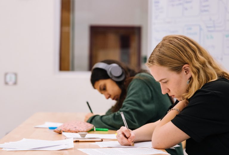 This is education - two teenagers in class writing and studying